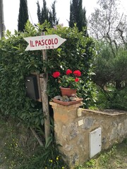 Naklejka premium Rustic Italian Directional Sign and Stone Wall in Tuscany Countryside
