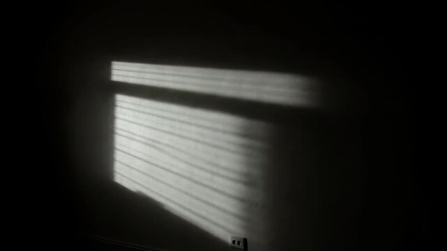 Silhouette of Person Watching Light Through Window at Night.