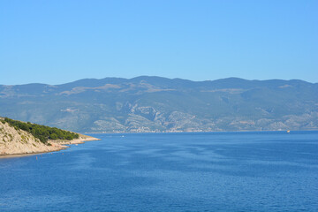 Fototapeta premium Beautiful coastal view of the blue Adriatic sea in Bunculuka bay on Krk island with the village of Sveti Juraj in the distance.