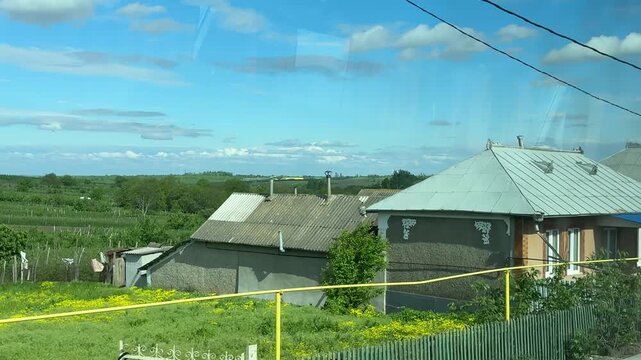 Traditional Moldovan village houses seen from bus window during countryside road trip from Ukrainian border