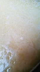 Fototapeta premium close up of a foam appearing at the opening of wastewater from the food processing industry, water texture