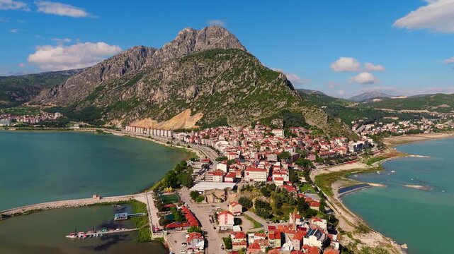 drone aerial of Lake Egirdir peninsula with high mountain peaks in the background. Scenic coastal settlement and lakeside village scenery in Turkey