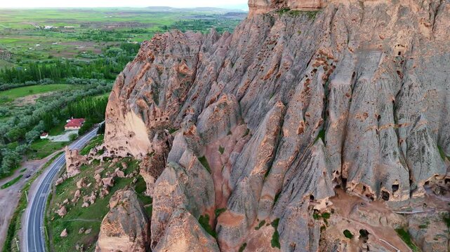 aerial massive steep volcanic cliffs containing Selime Cathedral caves. Historic rock-cut christian monastery structure in Cappadocia, Turkey
