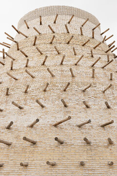 Brick tower of Ark Fortress in Bukhara with protruding wooden pegs embedded in the masonry. Ancient Central Asian fortification architecture ideal for travel and history publications.