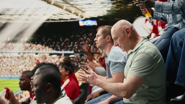 Frustrated mature supporter losing live betting wager on mobile sportsbook app, watching live match and high-risk betting odds, tension and pressure from a lost bet ticket in packed stadium.