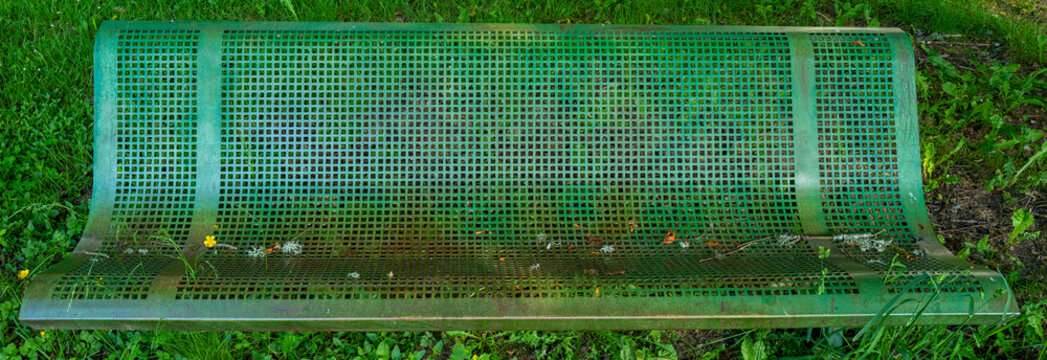 banc public en m&eacute;tal perfor&eacute; dans l'herbe