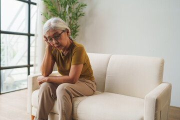Obraz premium Senior asian woman feeling tired having headache at home