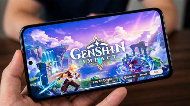 Genshin Impact by HoYoverse mobile logo app on a screen smartphone. Genshin Impact is an open-world action RPG developed by HoYoverse, featuring anime-style visuals and a vast fantasy world environmen