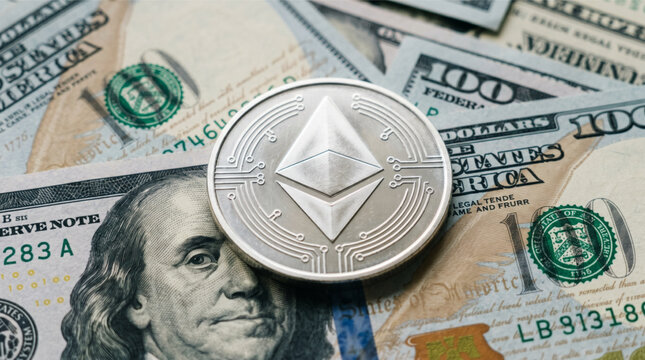 Silver Ethereum physical coin cryptocurrency on top of US hundred dollar bills. Ethereum is a decentralized, open-source blockchain with smart contract functionality and native currency Ether.