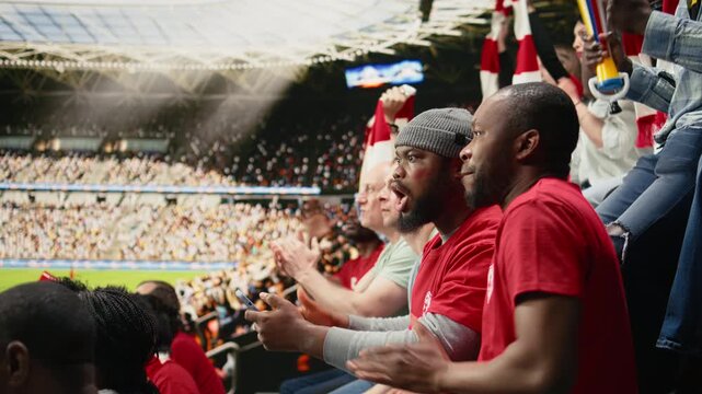 Passionate black fans following live betting odds on smartphone, cheering during exciting football match at stadium, supporters use betting apps to place wager, checking bet ticket with anticipation.