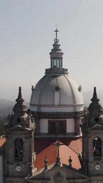 Vertical aerial pullback of the church dome and bell towers at Sameiro Sanctuary in Braga, Portugal.