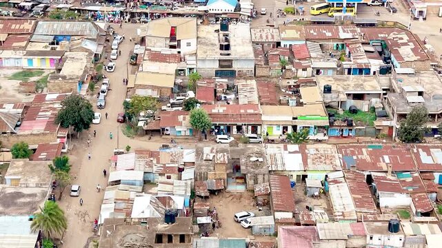 A cinematic view of rural Kenya showcasing informal settlements with rusted tin roofs, weathered homes, dusty village paths, and everyday community life.