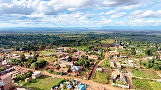 A cinematic view of rural Kenya showcasing informal settlements with rusted tin roofs, weathered homes, dusty village paths, and everyday community life.