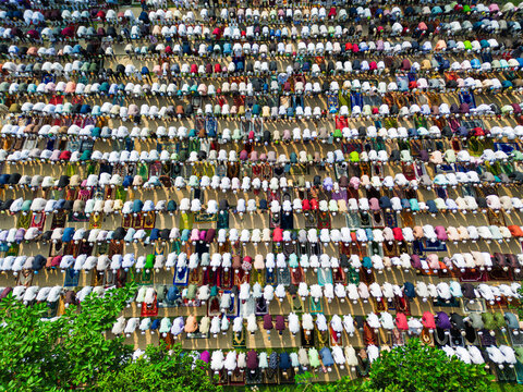 Joypurhat, Bangladesh - 28 May 2026: Aerial view of a large congregation of Muslim men performing prayer in organized rows on colorful mats during a religious festival.