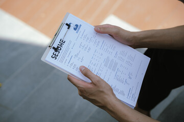 Naklejka premium Job applicant reviewing a resume document before an interview, reflecting career planning, employment opportunities, job search preparation, and professional development.