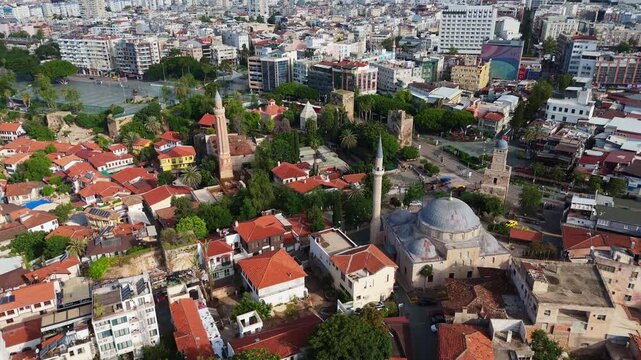 ottoman mosque dome surrounded by residential neighborhood houses in Kaleici old town. Cultural heritage site scenery in Antalya, Turkey drone aerial footage 