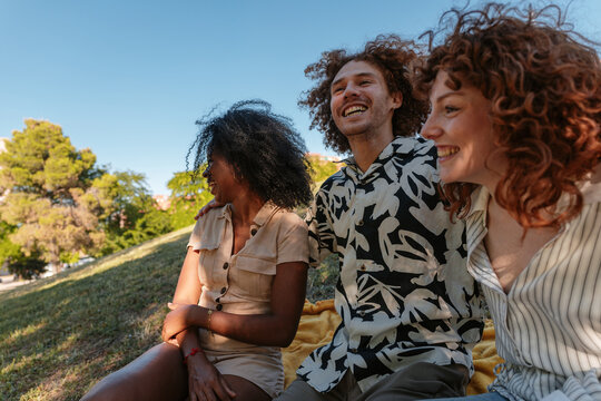 Diverse friends laughing and enjoying a picnic in the park