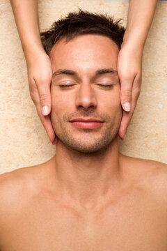 Germany, man receiving facial massage, close-up