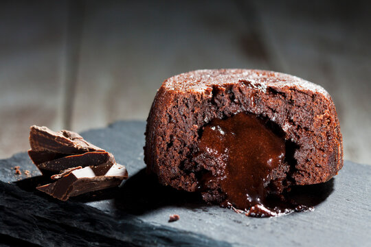 Sliced small chocolate tart with melted chocolate filling on slate