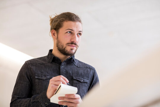 Portrait of young man with wrting pad and pencil
