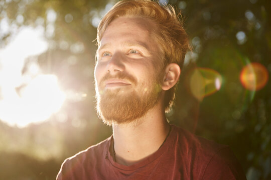 Smiling young man in backlight outdoors