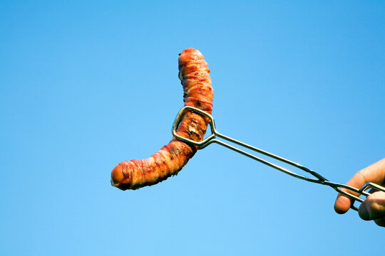 Man holding sausage with gripper