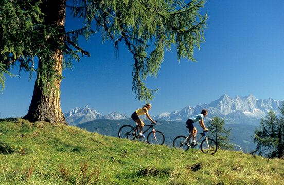 Austria, Salzburger Land, couple mountain biking, side view