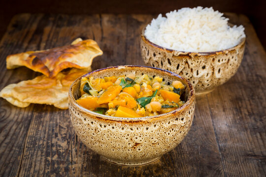 Curry dish with cauliflower, butternut pumpkin, spinach and coriander, papadam and rice