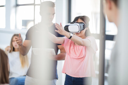 Teacher with tablet student wearing VR glasses in class