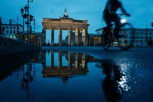 Germany, Berlin, view to Brandenburg Gate reflecting in puddle by night