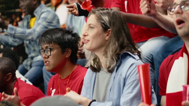Woman football fan watching tense soccer match from stadium stands, emphasizing modern football and inclusion in sports with fan scarves.