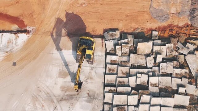 Aerial footage of a construction site with excavators at work, excavated concrete, new road construction, building and construction projects, and industrial areas. Business development manufacturing 