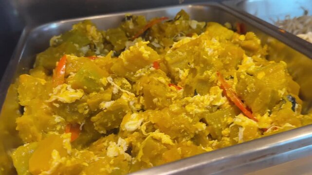 Close up video of stir fried pumpkin dish with savory seasoning and soft golden texture