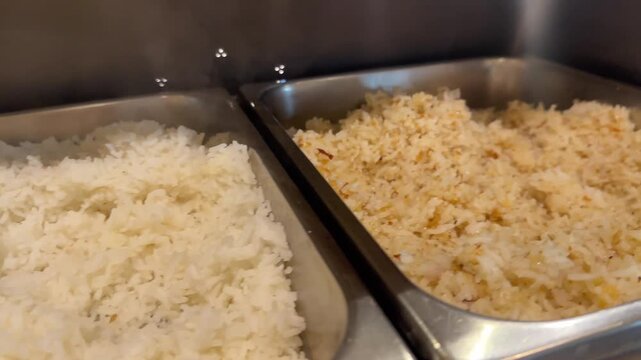 Video of metal steamer pans with steamed rice and fried rice in hot buffet food display