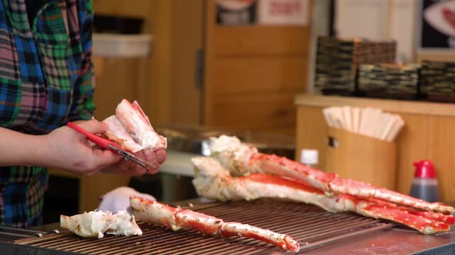 Chef Cutting Red King Crab Legs with Scissors at Seafood Market