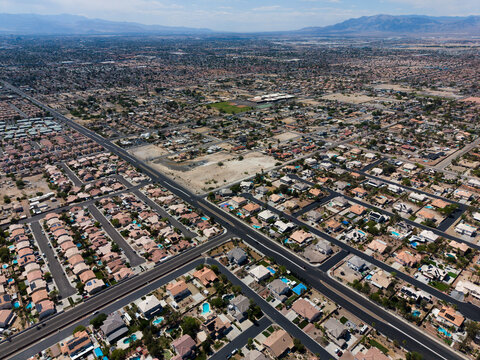 Wide aerial view of vast desert residential valley with distant mountains