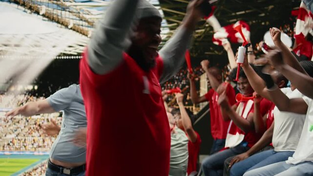 Excited diverse supporters jumping after winning live bet result, stadium crowd with adrenaline enjoying team victory, happy fans celebrate successful sports betting with raised fists, lucky win.