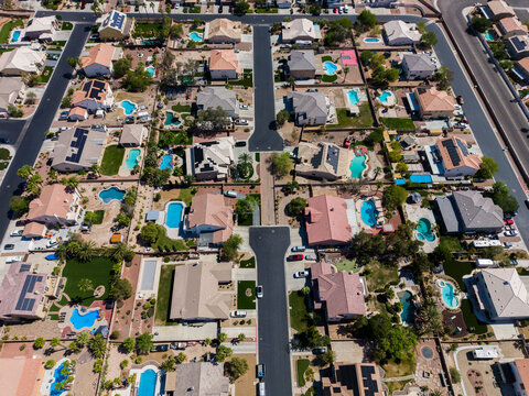 Overhead drone view of affluent residential houses with luxury backyard swimming pools