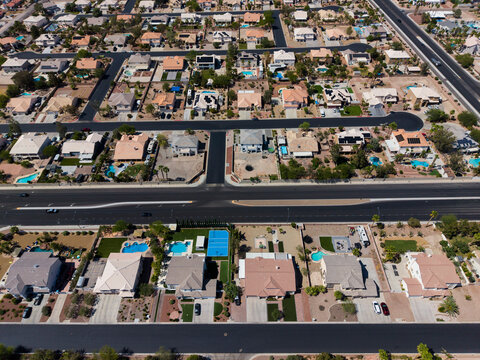 Overhead drone view of affluent residential houses with luxury backyard swimming pools
