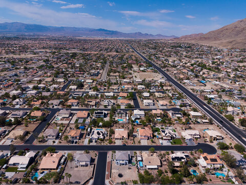 Wide aerial view of vast desert residential valley with distant mountains