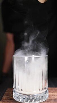 Copa de c&oacute;ctel llena de humo de ahumador de madera. Elegante copa de c&oacute;ctel cubierta con un denso humo arom&aacute;tico. C&oacute;ctel ahumado, t&eacute;cnica visual de bar vanguardista.