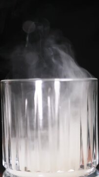Copa de c&oacute;ctel llena de humo de ahumador de madera. Elegante copa de c&oacute;ctel cubierta con un denso humo arom&aacute;tico. C&oacute;ctel ahumado, t&eacute;cnica visual de bar vanguardista.