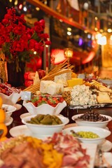 Fototapeta premium A banquet spread of assorted cheese, breadsticks, strawberries, olives and fruit elegantly arranged for an evening event