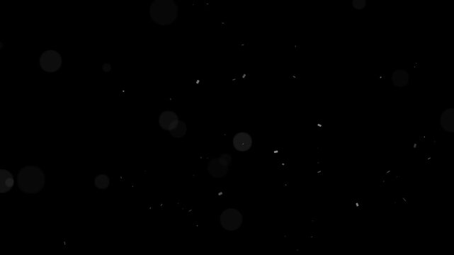 Soft abstract bokeh light particles and dust motes gently float and move slowly across a dark background