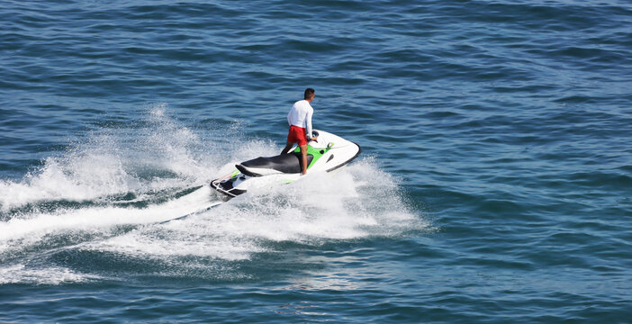 man driving jet ski on a calm blue water