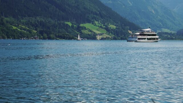 Passenger Boat Moving Across Lake With Mountain Background