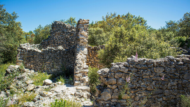 Ruined stone houses of the Moorish village Atzuvieta stand abandoned in the countryside under a bright sky
