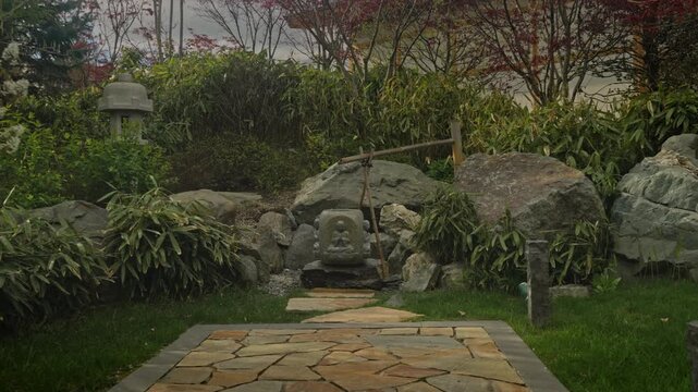 Stone Pathway To Mossy Statue Leading Through Rock Garden, Stepping Stones, Bamboo Accents And Lantern, Calm