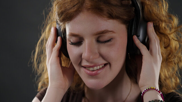 Young woman relaxing and enjoying music with closed eyes and a happy smile
