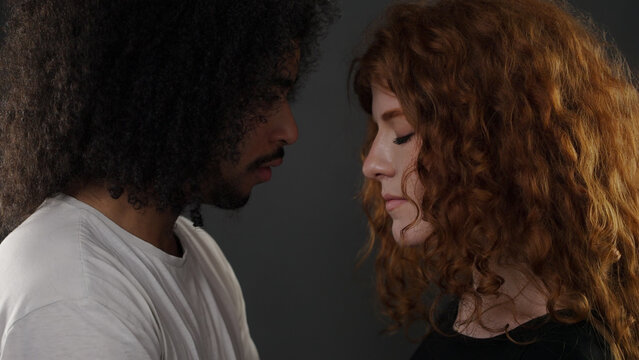 Diverse couple sharing a tender moment with eyes closed, expressing intimacy and connection